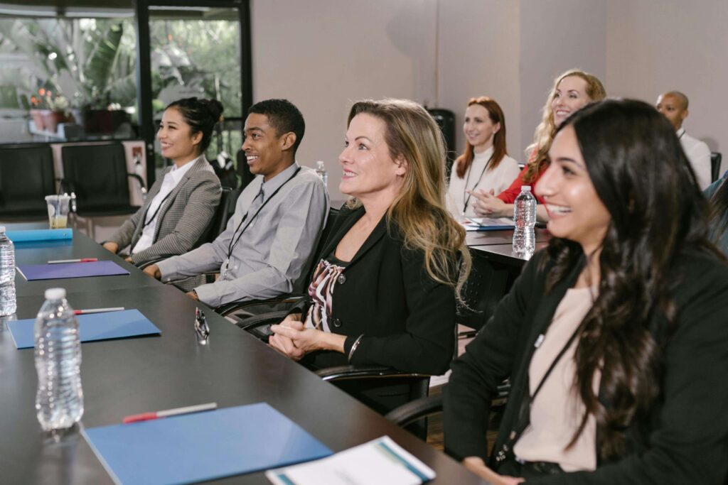 group of employees sitting at table and listening to speaker