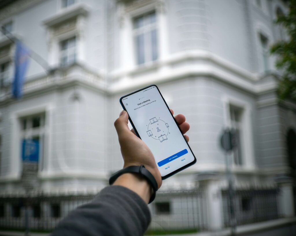 person holding up cell phone in city street