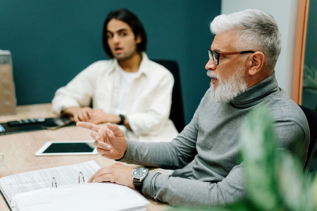 two men sitting at a table during a training session